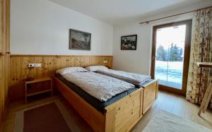 a bedroom with a large wooden bed with a window at Almhäuser Filzsteinalpe Almhaus 206 in Krimml