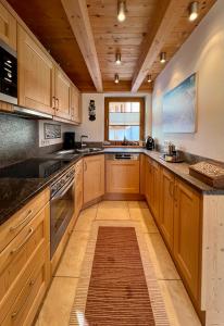 a large kitchen with wooden cabinets and a wooden ceiling at Almhäuser Filzsteinalpe Almhaus 206 in Krimml +1 photo