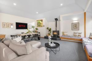 a living room with two couches and a fireplace at Tree Top Retreat in Central City - By KOSH BNB in Hamilton