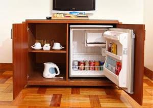 a small refrigerator with its door open in a kitchen at City Garden Suites in Manila