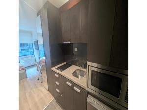 a kitchen with a sink and a microwave at Cosy City Studio Apartment in Melbourne