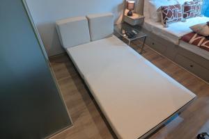 a bed in a room with a white mattress at Cosy City Studio Apartment in Melbourne