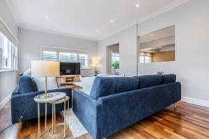 a living room with a blue couch and a table at VAQUAY El Karnak In Brunswick West in Melbourne
