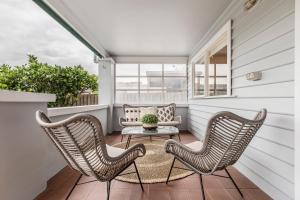 a porch with two chairs and a couch at VAQUAY El Karnak In Brunswick West in Melbourne