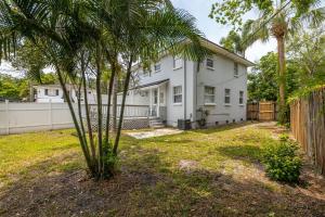 a palm tree in front of a white house at 1 Bedroom Unit in Hyde Park House in Tampa