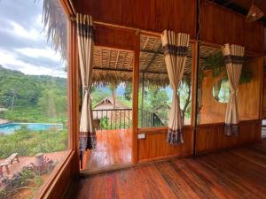 an empty room with a large window in a house at Pù Luông Ecolodge in Pu Luong