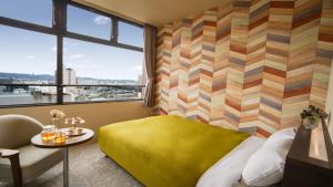 um quarto com uma cama amarela e uma janela em Hotel New Gaea Yanagawa em Yanagawa