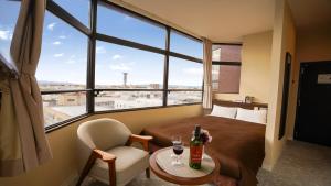 柳川市にあるホテルニューガイア柳川のベッド、テーブル、窓が備わる客室です。