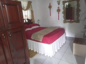 a bedroom with a bed with red sheets and a mirror at The Quiet Escape Loft in Kingston