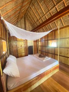 uma cama numa rede de descanso num quarto de madeira em Lily's Beach Bungalows em Koh Rong Island