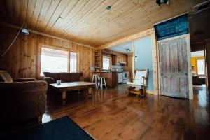 a living room with a couch and a table at Le Chalet des Coteaux in LʼAnse-Saint-Jean