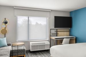 Cette chambre comprend un lit et une télévision. dans l'établissement TownePlace Suites by Marriott Wentzville, à Wentzville