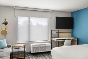 a hotel room with a bed and a tv at TownePlace Suites by Marriott Wentzville in Wentzville