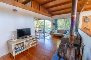 a living room with a television and a couch at Treeside - Sleeps 6 in Point Lookout