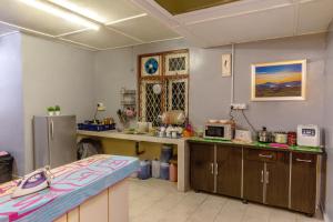 a large kitchen with a counter and a refrigerator at Vintage Guesthouse in Tanah Rata