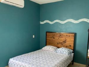 サン・アンドレス・トゥストラにあるNice house Casa de Descanso en San Andrés Tuxtla.の青い壁のベッドルーム1室
