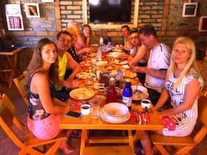 a group of people sitting at a table eating food at Vila Boska Palic in Palić