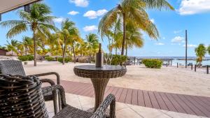 een tafel en stoelen op het strand met palmbomen bij LionsDive Beach Resort in Willemstad