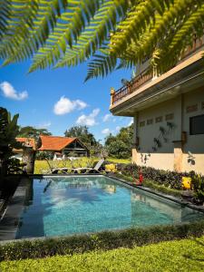 uma piscina no pátio de uma casa com um edifício em Nirwa Ubud Karma em Ubud