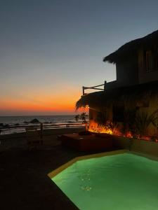 a resort with a swimming pool in front of the ocean at Sebastian de los milagros in Zipolite