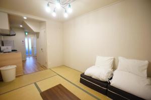 a living room with a couch with pillows on it at 【SHO-HOUSE】駅から徒歩3分 in Osaka