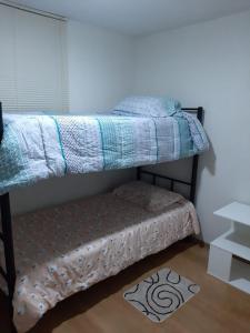 um quarto com um beliche com um repousa-pés por baixo em Piso 21 - Habitaciones en departamento - compartido em Lima