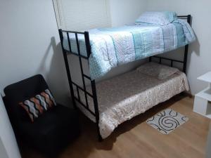 ein Schlafzimmer mit einem Etagenbett und einem Stuhl in der Unterkunft Piso 21 - Habitaciones en departamento - compartido in Lima