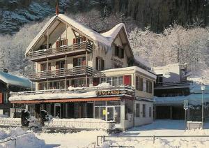 a large building covered in snow in front at Hotel Restaurant Jungfrau in Lauterbrunnen