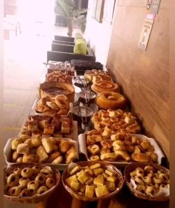 a buffet of different types of donuts and pastries at Encantos de itaperapuã in Porto Seguro