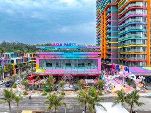 een groot kleurrijk gebouw met een park ervoor bij Flamingo Hải Tiến in Nam Khê