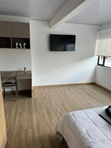 1 dormitorio con cama, mesa y escritorio en Apartamento tipo Loft nuevo, en Bogotá