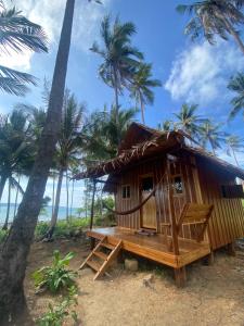 uma pequena cabana na praia com palmeiras em Lily's Beach Bungalows em Koh Rong Island