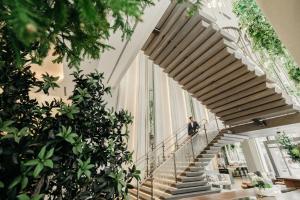Ein Mann geht die Treppe hinunter in einem Gebäude mit Pflanzen in der Unterkunft The Ritz-Carlton, Portland in Portland