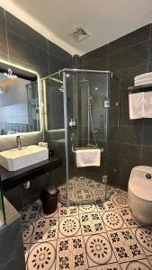 La salle de bains est pourvue d'une douche, d'un lavabo et de toilettes. dans l'établissement Mango Hotel - Ha Noi Railway station, à Hanoï