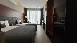 um quarto de hotel com duas camas e uma janela em Mango Hotel - Ha Noi Railway station em Hanói