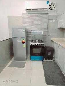 eine kleine Küche mit einem Herd und einem Kühlschrank in der Unterkunft السلطان شقق سكنية مستقلة Private independent in Medina