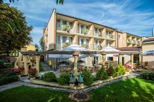 a hotel with an outdoor patio with tables and umbrellas at Hotel Pietrak in Trzemeszno