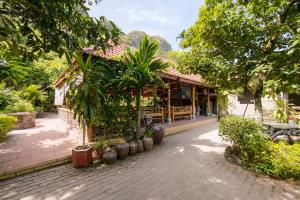 a building with trees and plants in front of it at Viet Hai Lan Homestay in Cat Ba