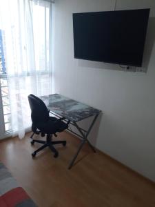 escritorio con silla y TV en la pared en Piso 21 - Habitaciones en departamento - compartido, en Lima