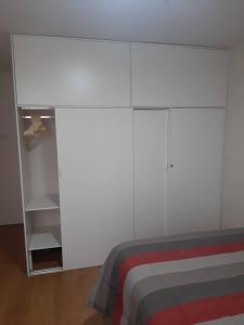 1 dormitorio blanco con 1 cama y armario blanco en Piso 21 - Habitaciones en departamento - compartido en Lima