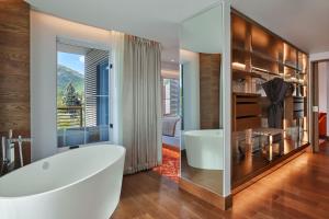 a bathroom with a large white tub and a large window at W Aspen in Aspen