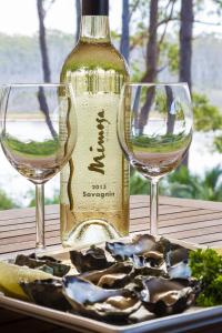Una botella de vino y dos copas en una mesa. en Tanja Lagoon Camp en Tanja