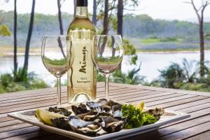 a bottle of wine and two glasses on a table at Tanja Lagoon Camp in Tanja