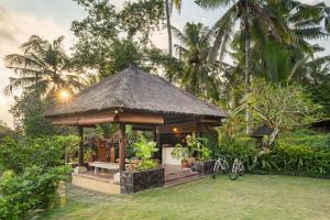 einen kleinen Pavillon in einem Garten mit zwei Fahrrädern in der Unterkunft Villa Semana Resort & Spa in Ubud