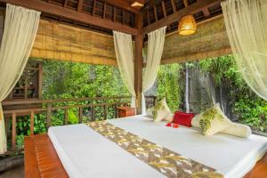 Bett in einem Zimmer mit einem großen Fenster in der Unterkunft Villa Semana Resort & Spa in Ubud