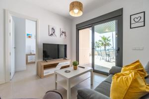 a living room with a couch and a tv at El amanecer, Apartamento 1 linea de playa in Vélez-Málaga