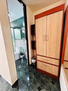 a bathroom with a wooden cabinet and a mirror at Hotel Arequipa Center in Arequipa