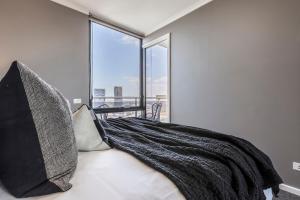 メルボルンにあるVAQUAY Enigma In Southbankのベッドと大きな窓のある寝室 +31枚の写真