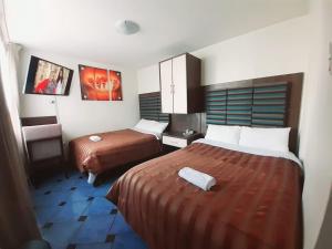 a hotel room with two beds and a tv at Hotel Arequipa Center in Arequipa