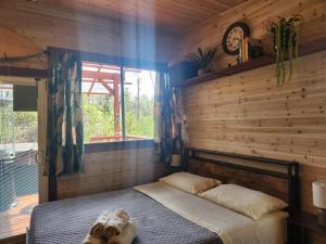 1 dormitorio con 1 cama y reloj en la pared en cabin 6 new cottage with private hot tub en Fern Forest